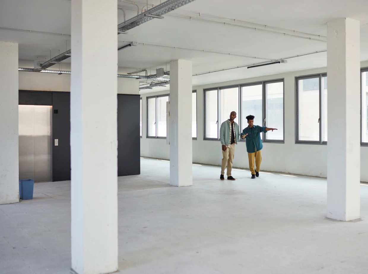 Two people in an empty office space.