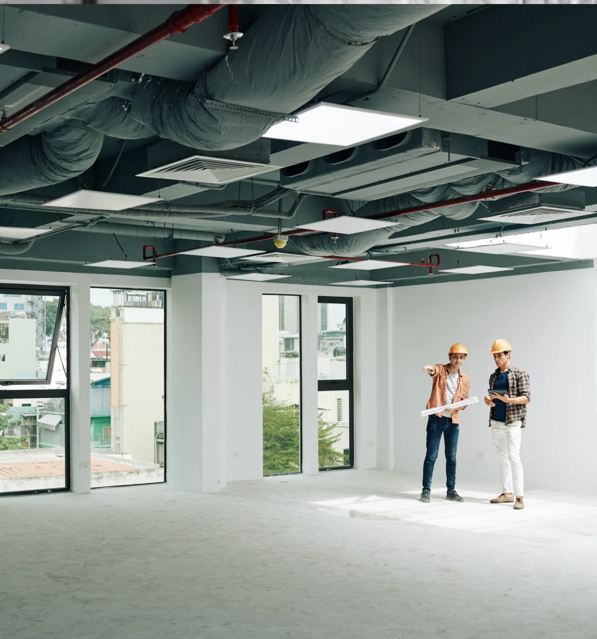 Two engineers discussing in empty office space.